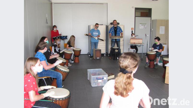 Mit Musiklehrerin Agnes Hehenberger (Vierte von links) und Djemepädagogen Gerd Fenzl (Dritter von rechts) erlebten Schülerinnen und Schüler einen etwas anderen Musikunterricht mit Djembe-Trommeln und Percussioninstrumenten. Bild: sei