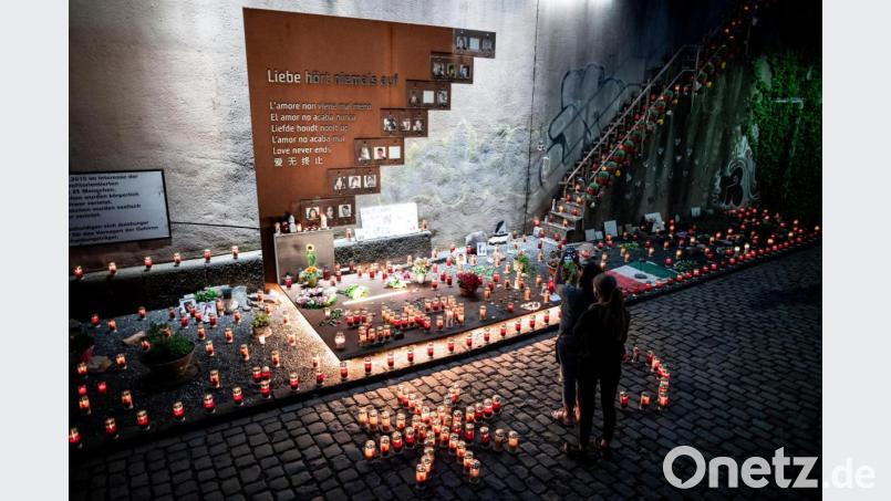 Menschen stehen vor Kerzen an der Gedenkstätte. Vor dem 10. Jahrestag der Massenpanik bei der Loveparade, bei der 21 Menschen sterben, findet die «Nacht der 1000 Lichter» statt. Im stillen Gedenken an die Opfer des Loveparade-Unglücks zünden Menschen Kerzen an der Gedenkstätte und dem Tunnel an der Karl-Lehr-Straße am Vorabend des Jahrestages an. Bild: Fabian Strauch/dpa