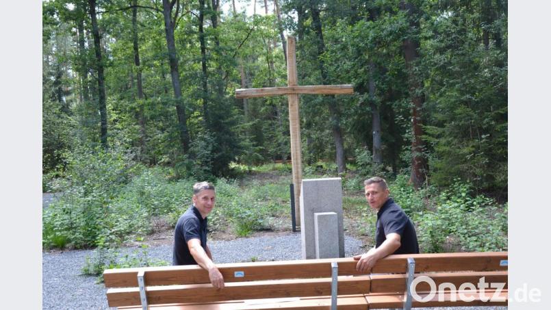 Der Waldfriedhof in Eschenbach ist fertig. Auf der Bank vor einem großen Holzkreuz nehmen Revierförster Martin Gottsche (links) und Bürgermeister Marcus Gradl Platz, um die Ruhe, die der Friedhof mitten im Wald ausstrahlt, auf sich wirken zu lassen. Bild: Anne Wiesnet