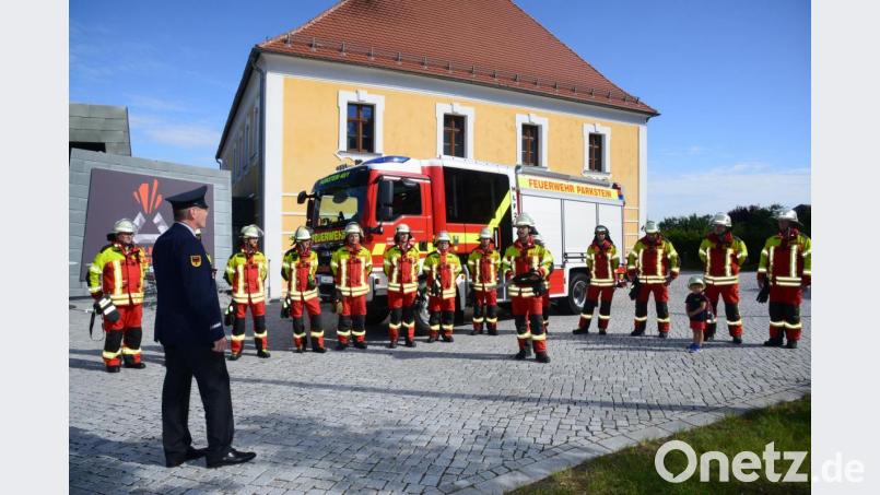 Kommandant Stefan Bäumler (rechts im Vordergrund) stellt vor dem Rathaus im Landrichterschloss das neue Feuerwehreinsatzfahrzeug HLF 20 vor und hält noch symbolisch den überdimensionalen Schlüssel in der Hand, den er dann Bürgermeister Reinhard Sollfrank (links, in blauer Feuerwehruniform) übergibt. Bild: bey