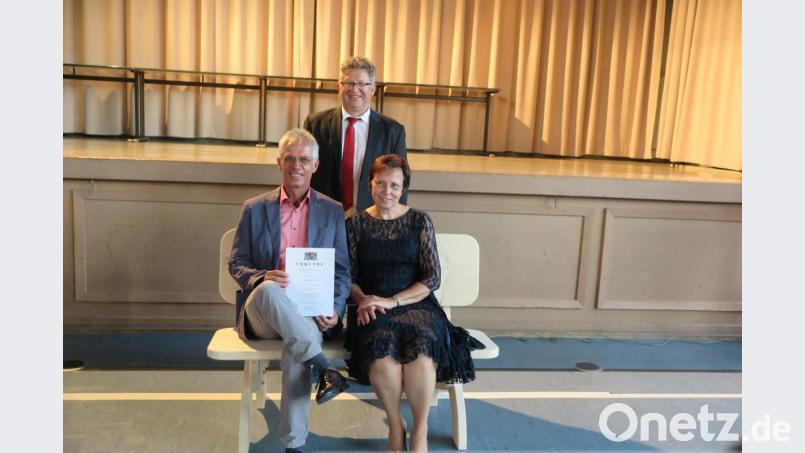 Alfons Nickl nahm mit seiner Ehefrau Claudia auf der Ruhebank Platz, die einige seiner Schüler für ihn zum Abschied gezimmert haben. Vorher hatte ihn Realschuldirektor German Helgert (stehend) verabschiedet. Bild: jzk