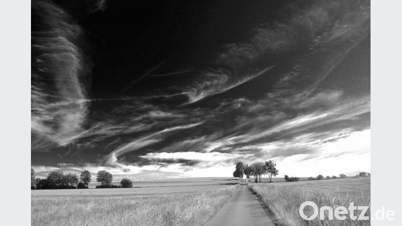 Ein mit dunklen Wolken bedeckter Himmel erscheint so noch bedrohlicher und kündigt ein unmittelbar bevorstehendes Unwetter an, so wie es auf dem Bild von der Frühlingslandschaft bei Kaimling zu sehen ist. Bild: Christian Höllerer
