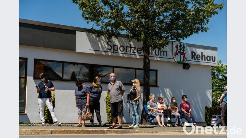 Menschen stehen Schlange, um sich bei einer mobilen Corona-Teststation in Rehau auf das Virus testen zu lassen. Nachdem in den vergangenen Tagen 15 Personen in Rehau positiv auf das Coronavirus Sars-Cov-2 getestet worden sind, stellt der Landkreis bis zum 24. Juli ein Testmobil bereit. Bild: Nicolas Armer/dpa