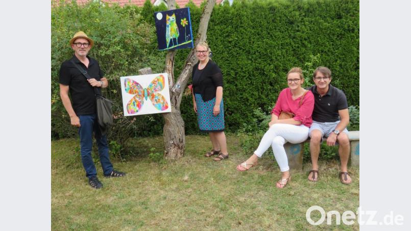 Hobbymalerin Cheryl Frank (Mitte) hat zu ihrer ersten Vernissage mit dem Titel „Kunst im Garten“ eingeladen. Ihre Gäste sind von den Werken beieindruckt. Bild: ow
