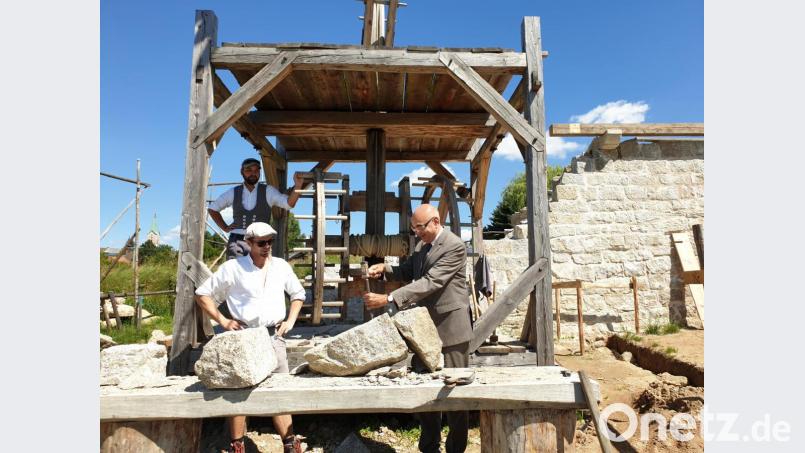 MdL Jürgen Mistol legte selbst Hand an und übte sich auf der Baustelle des Königshofes beim Steinebearbeiten. Michael Winkler und Robert Mois schauten zu.. Bild: awo