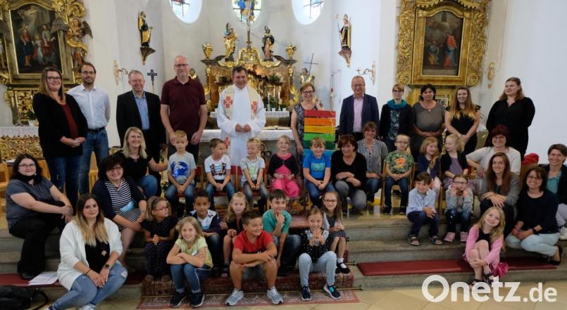 Beim Abschlussgottesdienst für die Vorschulkinder wird Roswitha Bergmann (rechts neben Pfarrer Max Früchtl) aus dem Kindergartenteam von St. Johannes Maria Vianney verabschiedet. Bild: le