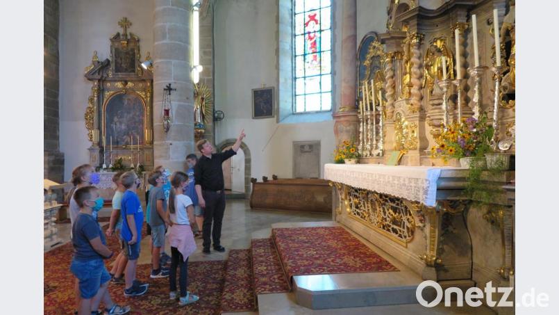 Bei der Kirchenführung erklärte Stadtpfarrer Thomas Kraus den Erstkommunionkindern den Hochaltar mit dem Tabernakel. Bild: jzk