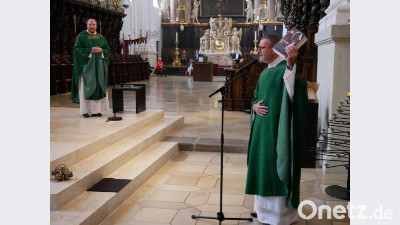 Stadtpfarrer Thomas Vogl überreichte dem scheidenden Pfarrvikar ein über 1000 Seiten umfassendes Buch über den emeritierten „bayerischen“ Papst Benedikt. Bild: hmr