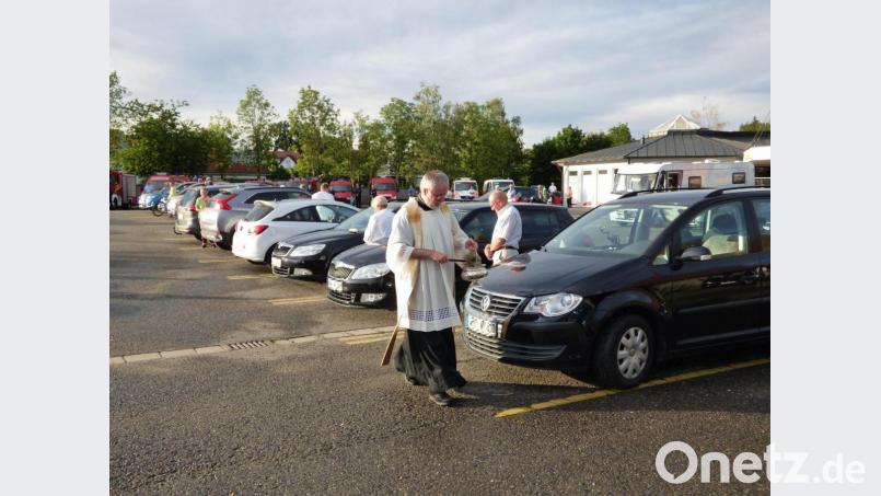 Segen für alles, was Räder hat, bevor es die Ferien- und Hauptreisezeit so richtig startet: Neben Autos stehen auch Zweiräder aufgereiht auf dem Parkplatz des Rewe-Marktes, um von Pfarrer Edmund Prechtl gesegnet zu werden. Bild: mng