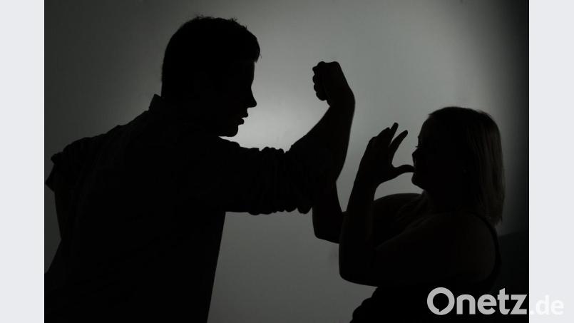 Ein als Silhouette abgebildeter Mann droht einer Frau mit der Faust. Symbolbild: Jan-Philipp Strobel/dpa