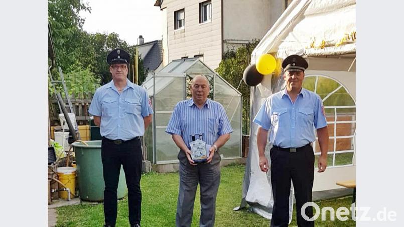 Armin Prischenk (rechts) und Martin Langer (links) gratulieren Josef Schmid im Namen aller Feuerwehrkameraden mit einem Geschenk zum 80. Geburtstag. Bild: jma