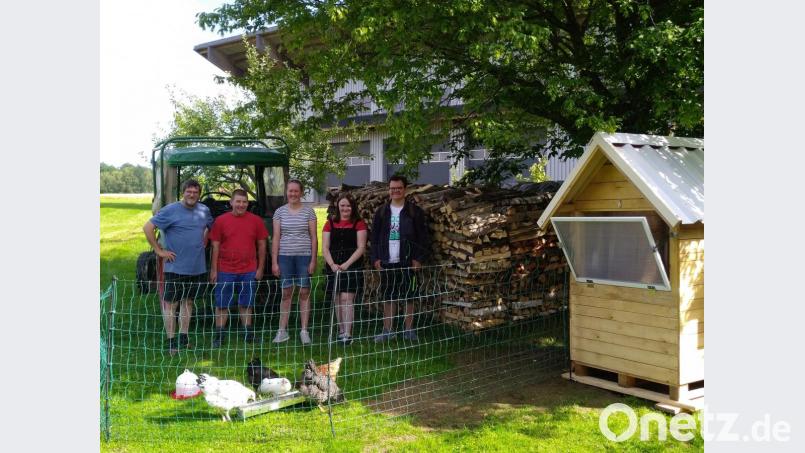 Lehrer Johann Wiesent (links) staunt nicht schlecht, als seine ehemaligen Schüler mit dem selbstgezimmerten Hühnerquartier samt Hühnern und Hahn in Erpetshof anrücken. Bild: dob