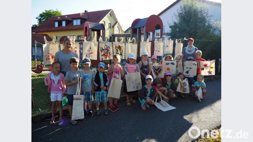 Mit ihrer Verkaufsaktion von selbstbemalten Einkaufstaschen unterstützen die Irchenriether Kindergartenkinder ihre Altersgenossen in Ruanda. Stolz präsentieren die Kleinen mit Leiterin Sabine Fillinger (hinten, rechts) und Anna Gall (hinten, links) ihre „Kunstwerke“ und hoffen auf großen Erfolg. Bild: grm
