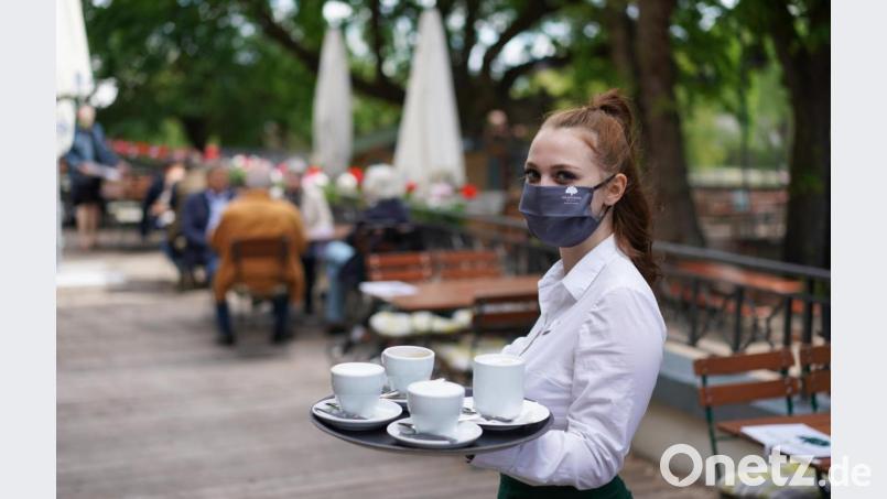 Wer in einem Biergarten nicht auf einem Platz sitzt, für den gilt die Maskenpflicht. Bild: Jörg Carstensen/dpa