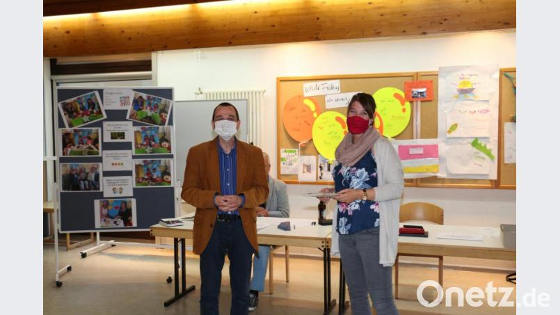 Pfarrer Hartmut Klausfelder verabschiedet Kindergartenleiterin Maria Grabenbauer in den Mutterschutz. Bild: rpp