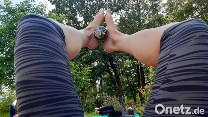 Verrenkungen beim Bieryoga: Ich liege auf dem Boden, und zwischen meinen Füßen klemmt eine Flasche Bier. Bild: Lowak