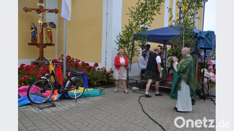Zum Abschied überreichten Pfarrgemeinderat, Kirchenverwaltung und der Frauenbund Moosbach dem scheidenden Pfarrer ein E-Bike, damit er sich im Ruhestand fit halten kann. Darüber freut sich auch PGR-Sprecherin Elisabeth Völkl. Bild: gi