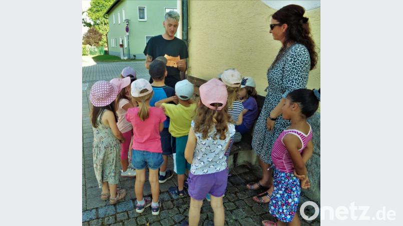 Durch ganz Kohlberg führte die Schnitzeljagd der Schulanfänger. Spannend ist, was Sebastian Reil vom Kindergartenteam da als neuen Hinweis vorliest. Auch Marion Eitel (Zweite. von rechts), die Leitern der Arche Noach, ist bei der Schatzsuche dabei. Bild: jml