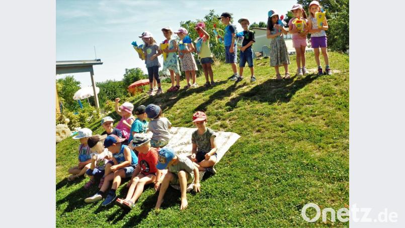 Die "Großen" oben am Spielhügel bekamen von den "Kleinen" zum Abschied aus dem Kindergarten selbst gebastelte Schultüten geschenkt. Bild: jml