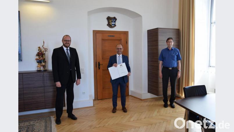 Landrat Andreas Meier (links) und Personalchef Edmund Frummet (rechts) gratulieren Alfred Scheidler (Mitte) zu der in der Geschichte des Landkreises Neustadt einzigartigen Beförderung zum Leitenden Regierungsdirektor. Bild: Landratsamt Neustadt a.d.Waldnaab/Marcel Weidner/exb