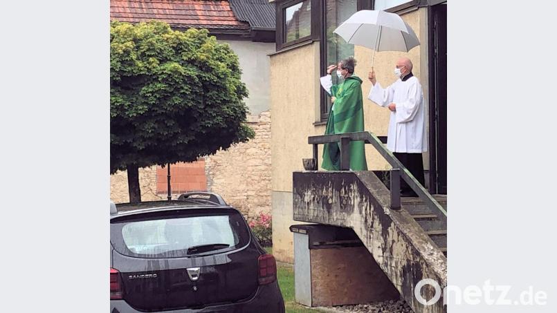 Pfarrer Werner Sulzer segnet die vorbeifahrenden Autos mit Weihwasser (bjo) Bild: bjo