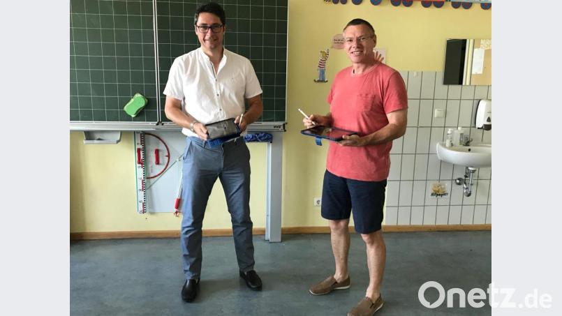 Bürgermeister Reinhard Sollfrank übergibt symbolisch die Leih-Tablets, die für Schüler gedacht sind, an Rektor Armin Aichinger. Bild: bey