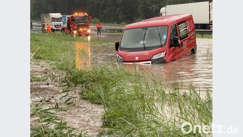 Ein Transporterfahrer hängt mit seinem Fahrzeug in den Fluten. Die Autobahn A8 steht bei Achenmühle unter Wasser. Bild: Bernd März/dpa