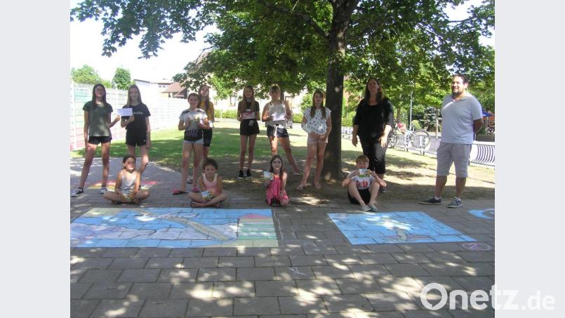 Stellvertretender Bürgermeister Oliver Becher (von rechts) und Jugendbeauftragte Alexandra Mark-Sischka überreichten an die erfolgreichen Künstler der Veranstaltung „Buntes Pflaster“ im Rahmen des Programms für interessante Ferien die Preise. Bild: öt
