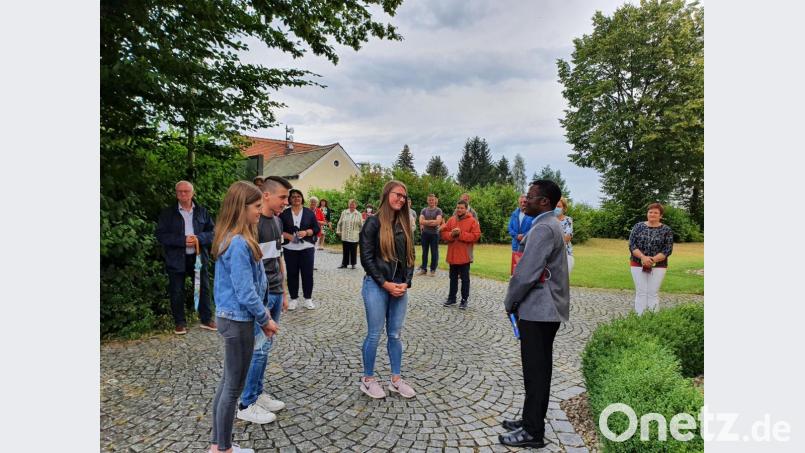 Unter anderem die Oberministranten von Plößberg Hanna Haubner, Simon Hildebrand und Annika Müller (von links) bedankten sich mit einem kleinen Geschenk für das Wirken des Pfarrvikars Florent Mukulay Mukuba (rechts) in den letzten beiden Jahren in der Pfarreiengemeinschaft Beidl Plößberg. Bild: flt
