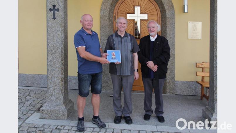 Im Namen der Dorfgemeinschaft und des Kapellenfördervereins Gebhardsreuth überreichte Vorsitzender Reinhold Baier (links) an Pfarrer Josef Most ein Fotobuch vom Kapellenbau. Mit dabei Pater Berthold. Bild: gi