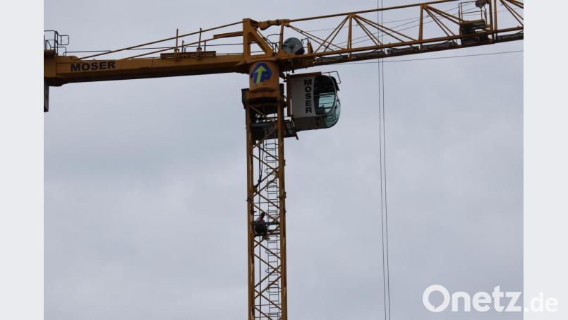 Ein Bauarbeiter sitzt auf einem Kran und weigert sich herunterzukommen. Bild: Alexander Auer