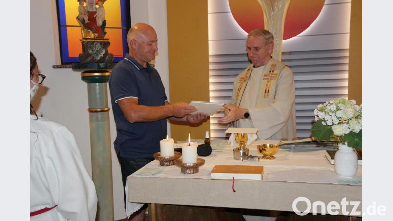 Im Namen der Dorfgemeinschaft und des Kapellenfördervereins Gebhardsreuth überreicht Vorsitzender Reinhold Baier Pfarrer Josef Most ein Fotobuch vom Kapellenbau. Bild: gi