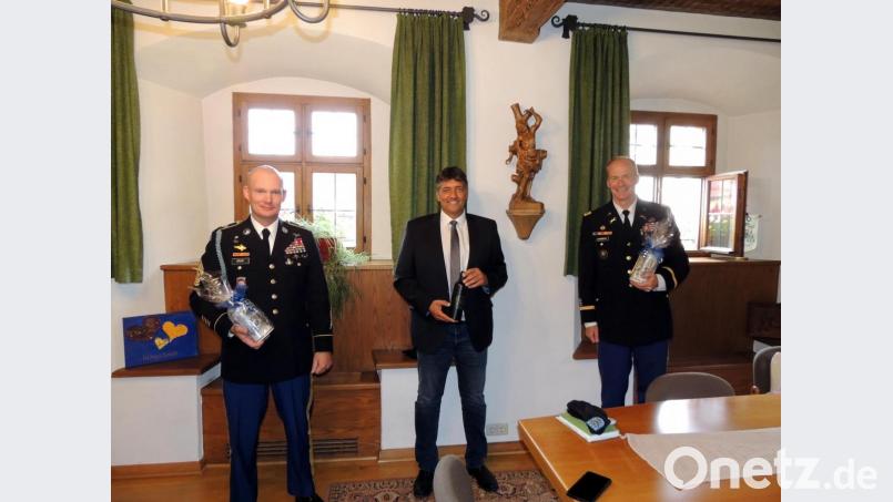 Bayerische Bierkrüge mit dem Stadtwappen gegen eine Radlertrinkflasche mit dem Wappen der US-Garnison Bavaria tauschen Bürgermeister Edgar Knobloch (Mitte) mit Oberst Christopher Danbeck (rechts) und CSM Michael Spear im Rathaus aus. Bild: mor