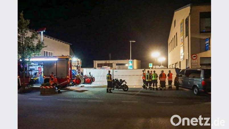 Feuerwehrleute stehen in der Nähe des Tatorts vor der Zufahrt zu einem Supermarkt. Bild: Markus Zechbauer/dpa