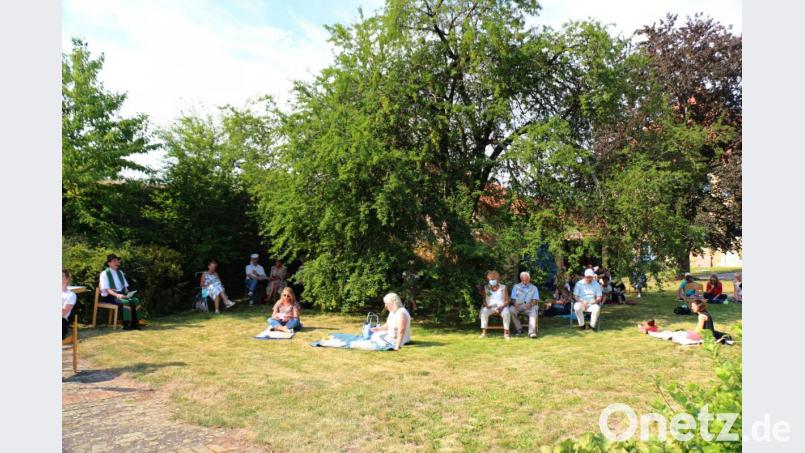 Die Gottesdienstbesucher verteilen sich im ganzen Pfarrgarten. Bild: rpp