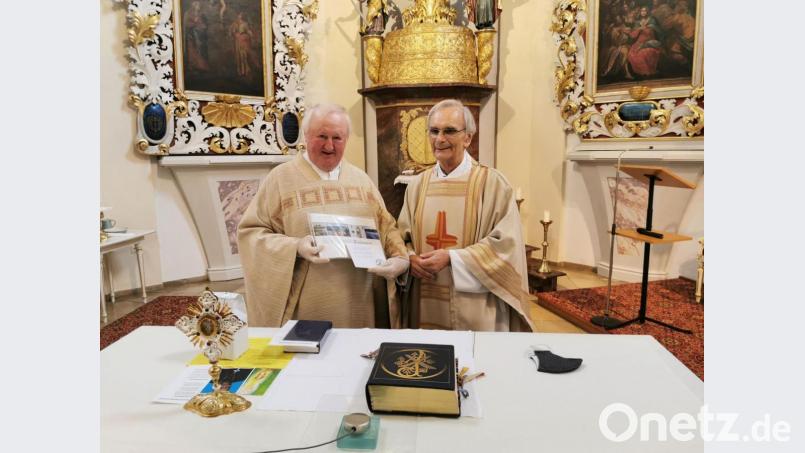 Pfarrer Erwin Bauer überreicht dem Ruhestandsgeistlichen Herbert Zimmermann einen Eslarner Bildband und das Kräuterelixier von Dr. Eisenbarth. Bild: gz