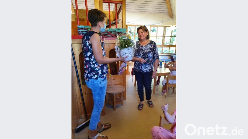 Evelyn Lanzl überreicht mit Dankesworten an die scheidende Erzieherin Edeltraud Hampl Blumen mit einem Gutschein. Bild: sl