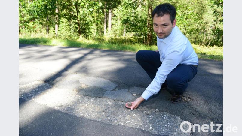 Die Asphaltdeckschicht auf der Gemeindeverbindungsstraße Oberwildenau-Kohlberg ist so marode, dass Bürgermeister Sebastian Hartl mit bloßen Händen Teile des Belags entfernen kann. Bild: bey