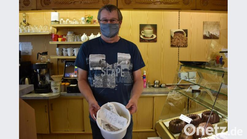 Günter Hühn vom Café Rieß am Marktplatz in Tirschenreuth hält einen Eimer in der Hand mit Kassenbons, die Kunden im Geschäft liegen lassen. Am Tag wird gut ein Eimer voll. Bild: lue