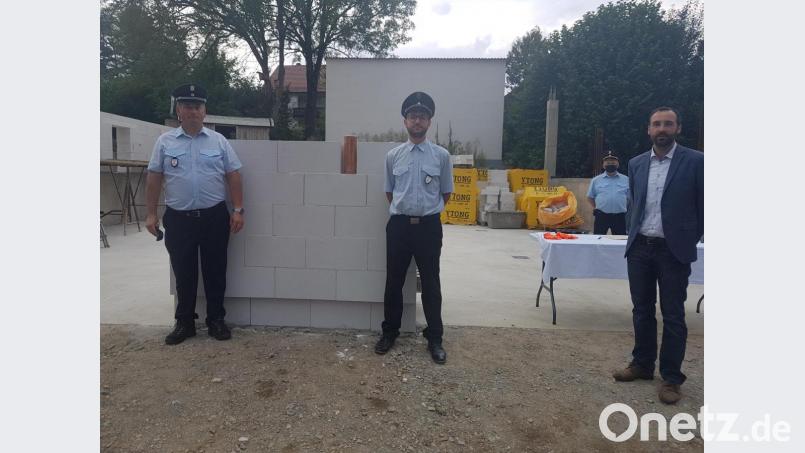 Bürgermeister Armin Bulenda, der Vorsitzende der Feuerwehr Burgtreswitz, Kilian Völkl, und Kommandant Peter Hartinger (von rechts) setzen den Grundstein mit einer Zeitkapsel aus Kupfer. Bild: gi
