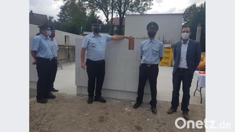 Bürgermeister Armin Bulenda, der Vorsitzende der Feuerwehr Burgtreswitz Kilian Völkl und Kommandant Peter Hartinger (von rechts) setzen den Grundstein mit einer Zeitkapsel aus Kupfer. Bild: gi