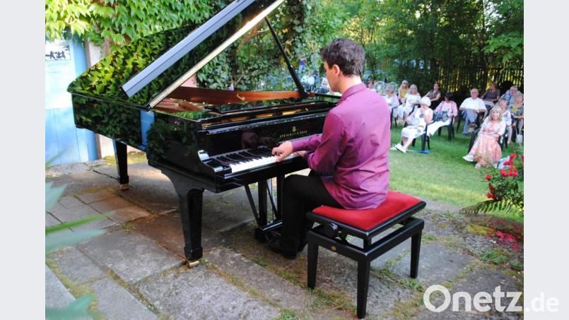 Kunstgenuss im Pfarrgarten. Die Zuhörer lauschen Vadim Chaimovich teils mit geschlossenen Augen Bild: gge