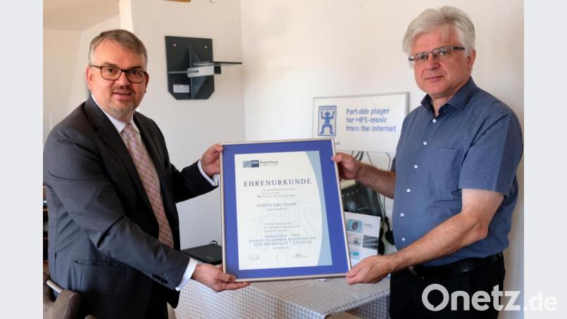 IHK-Geschäftsführer Markus Huber (links) überreicht Firmeninhaber Dipl.-Ing. Erich Böhm die Ehrenurkunde der Industrie- und Handelskammer Regensburg zum Jubiläum. Bild: mab
