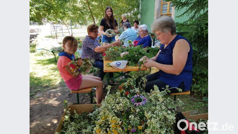 Eifrig binden die Frauen und Mädchen Kräuterkränzchen und -buschen zur Segnung an Mariä Himmelfahrt. Die Bevölkerung kann sie am Freitag, 14. August ab 15 Uhr im Garten am Pfarrheim erwerben. Bild: gi