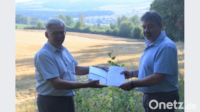 Bürgermeister Josef Hammer und Planer Roland Pflaum (von links) zeigen die Planunterlagen für den angestrebten Waldkindergarten in Irchenrieth kurz vor der Sitzung am Standort hoch über der Gemeinde. Die Kinder werden eine fantastische Aussicht genießen. Bild: fz