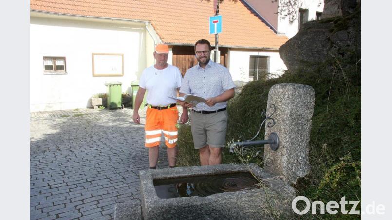 Ortstermin am Brauhaus mit Bürgermeister Grundler und Bauhofmitarbeiter Andreas Zölch (von rechts). Der vorhandene Granit-Brunnen wird zurückgebaut. An dessen Stelle wird die Zoigl-Skulptur mit den „Abträgern“ errichtet. An welcher Stelle der vorhandene Brunnen errichtet wird, bleibt aber noch offen. Bild: wro
