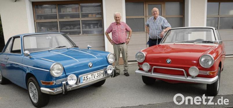 Vier Senioren auf einem Bild: Links der größere BMW 700 LS von 1969, rechts der aktuell restaurierte rote BMW 700 Coupé Baujahr 1961. Georg Lehner (links) und Eugen Fricke sind sehr stolz auf die kostbaren Stücke, die in Sammlerkreisen stolze fünfstellige Summen wert sind. Bild: ge