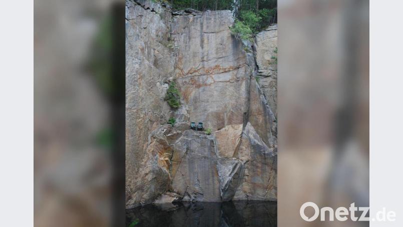 Zwei grüne Gartenstühle stehen seit einiger Zeit in einem ehemaligen Steinbruch auf einem schmalen Vorsprung mitten in der senkrechten Granitwand. Wie sie dorthin gekommen sind, ist ein Rätsel. Bild: tss