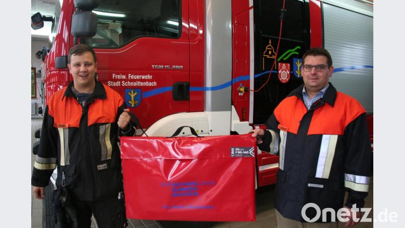 Kommandant Michael Werner (rechts) und Atemschutzleiter Lucas Reindl nehmen den von der Versicherungskammer Bayern gespendeten Rauchvorhang in Dienst und verlasten ihn auf dem neuen LF 20 KatS. Bild: wfw