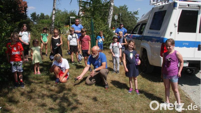 Den Umgang mit dem GPS-Gerät erklärte Martin Wührl (knieend rechts) zu Beginn auf der Ludwigshöhe und später im Wald. Geleitet wurde der kindgerechte Nachmittag mit der Bergwacht von Bereitschaftsleiter Wolfgang Hartung (hinten rechts). Eine der drei Gruppen betreute Markus Wührl (in der hinteren Reihe, Bildmitte). Bild: wro